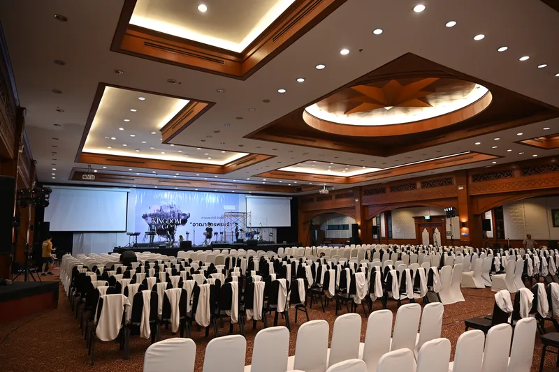 Tata panggung dan pencahayaan grand ballroom hotel mewah dengan deretan kursi banquet rapi dan panggung presentasi resmi acara perusahaan